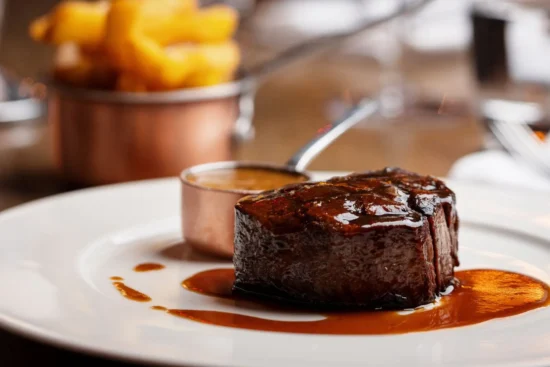 Irish fillet steak close-up with jus and pepper sauce in copper pot at Marco Pierre White Steakhouse & Grill Dublin 2