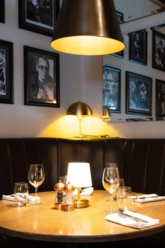 Interior dining table set for two with black and white photography wall at Marco Pierre White Steakhouse & Grill Dublin 2