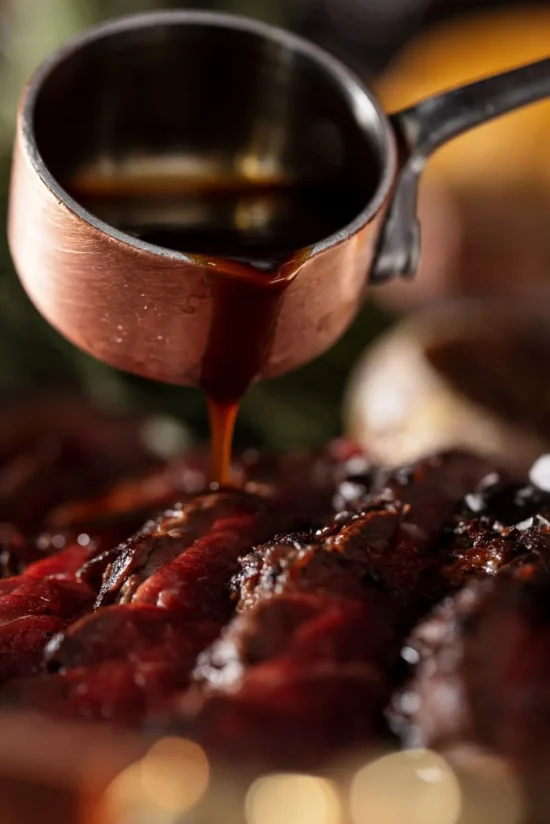 Jus pouring from copper sauce pot over sliced aged Irish beef at Marco Pierre White Steakhouse & Grill Dublin 2