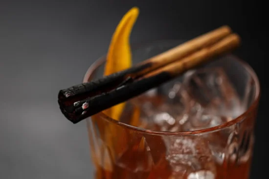 Smoked Old Fashioned cocktail with burnt cinnamon sticks and orange peel at Marco Pierre White Steakhouse & Grill Dublin 2